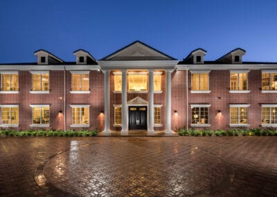 Elegant brick residential building with classic architecture and warm lighting at night.