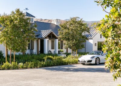 Luxury residential home with modern architecture and a sleek white car parked outside.