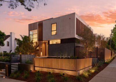 Modern contemporary house with sleek architecture and landscaped yard at dusk.