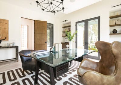 Bright and modern office interior with glass table, leather chairs, and natural light.