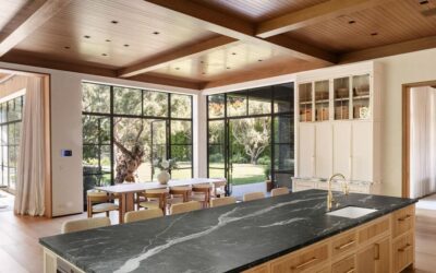Spacious kitchen featuring large windows, natural light, and a sleek black marble island for a styli.