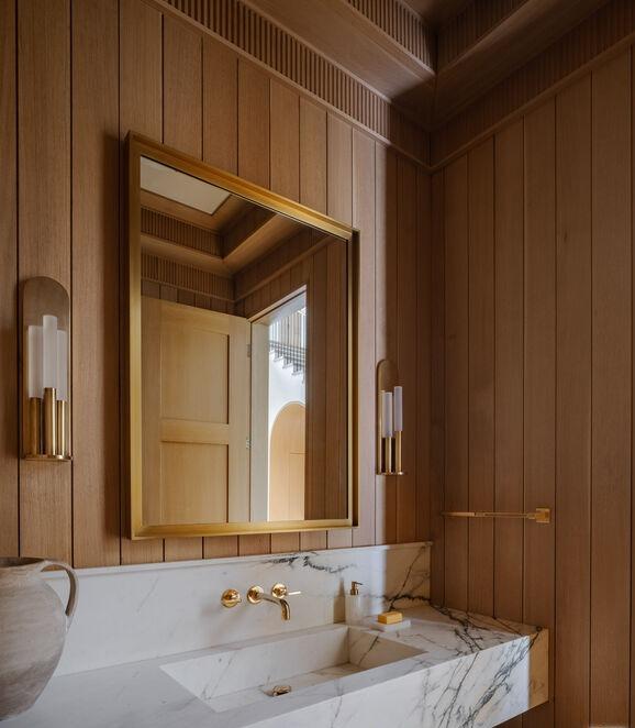 Bathroom interior with wood paneling and marble sink.