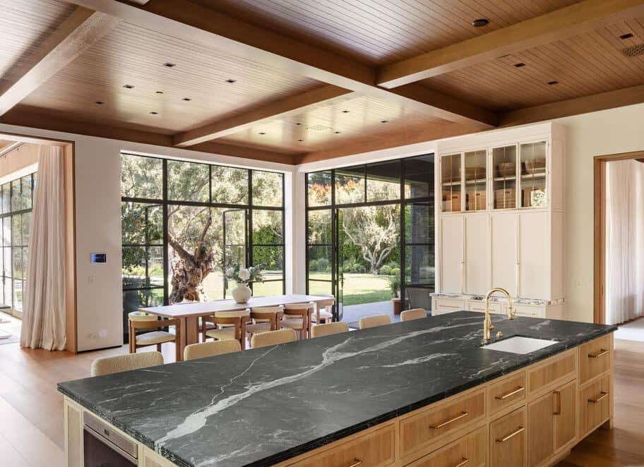 Kitchen with expansive glass windows and natural wood finishes, ideal for contemporary home designs.