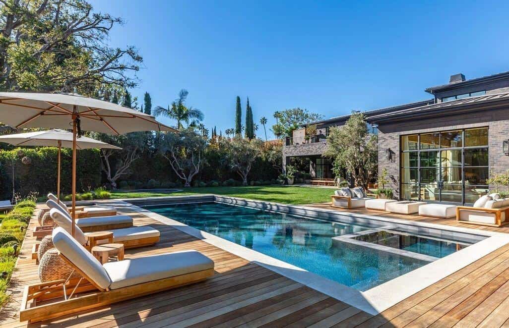 Modern outdoor pool with lounge chairs and lush greenery at Riviera Development Partners.